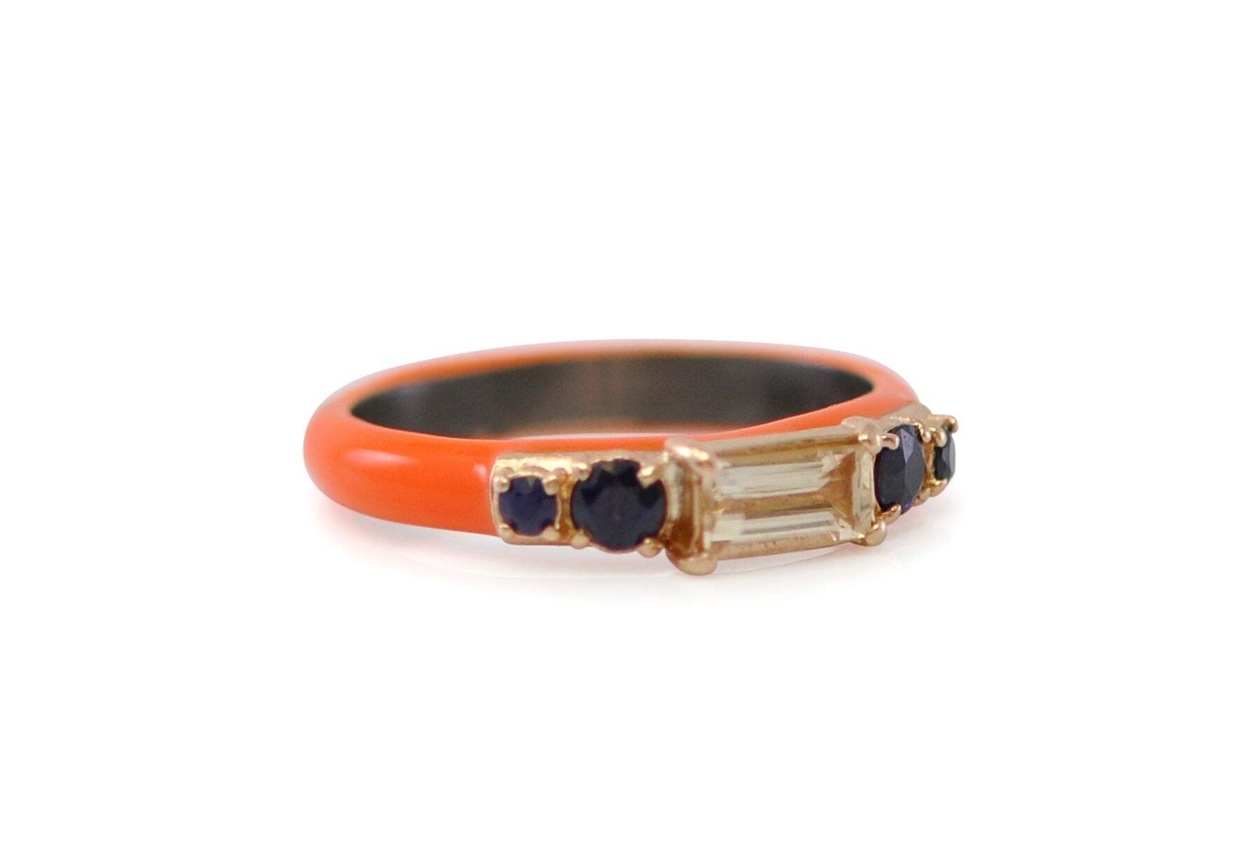 This exquisite 14k rose gold and blackened sterling silver orange enamel stack band is perfect for a timeless and sophisticated look. This stylish band features a peach imperial topaz baguette and blue sapphires, making it a truly unique and remarkable piece. The orange enamel and blackened silver create a modern take on a classic look and are sure to make you stand out from the crowd. The peach imperial topaz baguette and blue sapphires provide a beautiful contrast, adding richness and depth to the piece. Perfect for any special occasion or simply to add a touch of glamour to your day, this stunning stack band is sure to become a treasured part of your jewelry collection. Orange Enamel Stack Ring