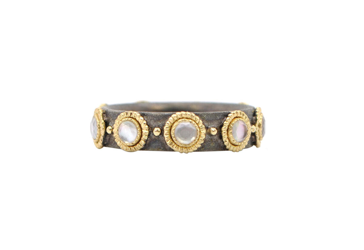 This exquisite 18k yellow gold and blackened sterling silver ring is the perfect combination of modern femininity and stylish sophistication. The band features granulation detailing, creating an elegant texture, and an intricate pattern of white mother of pearl and white quartz for an eye-catching display. With a band width of 0.20" (5.13mm), this ring is the ideal accessory for any fashion-forward woman. It is a timeless piece that you’ll cherish for years to come. White Mother of Pearl Stations Stack Ring