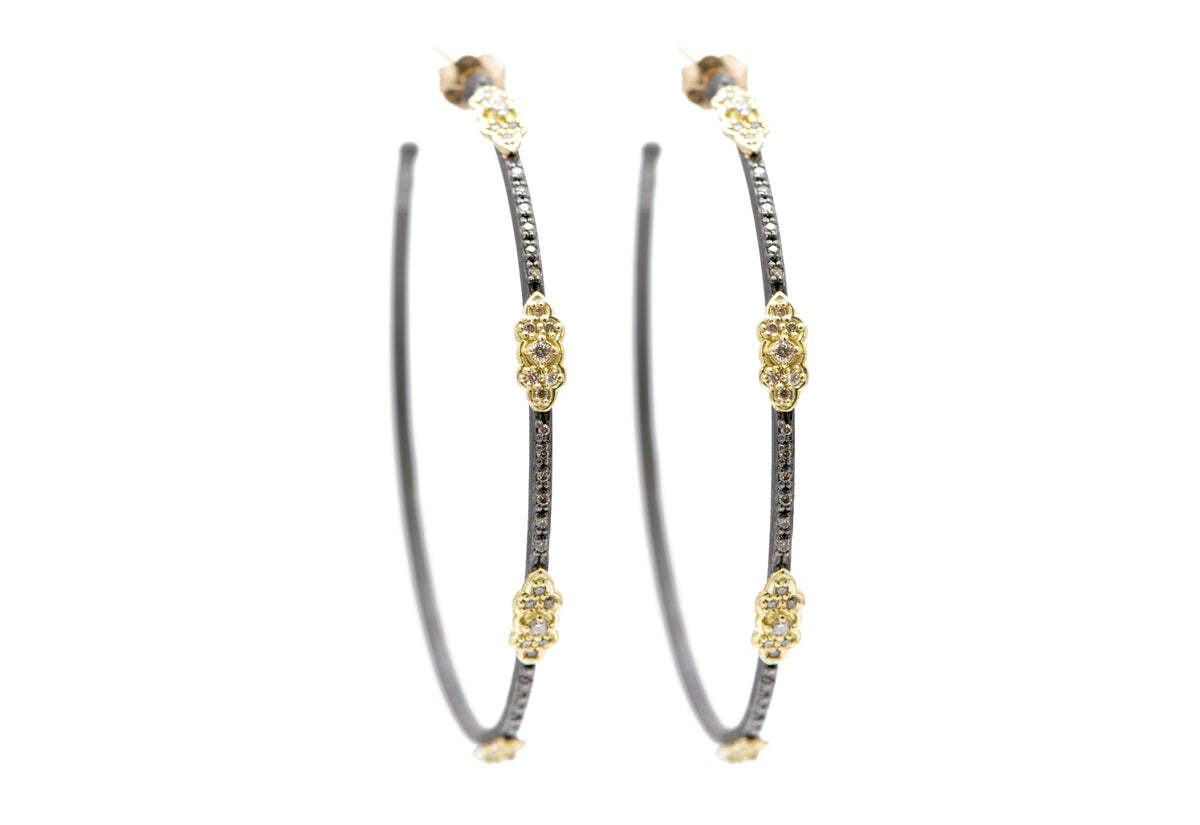 Make a timeless statement with these gorgeous 18K Yellow Gold and Blackened Sterling Silver Scroll Station Side Hoop Earrings with Champagne Diamonds (0.68 TCW). Showcasing a sleek and stylish 52mm hoop design, these earrings have been crafted from 18K yellow gold and blackened sterling silver for a unique contrast and added visual interest. Atop the hoop, a row of champagne diamonds (0.68 TCW) lend a beautiful sparkle to the design. Perfect for any special occasion, these elegant earrings will be cherished for years to come. Scroll Hoop Earrings