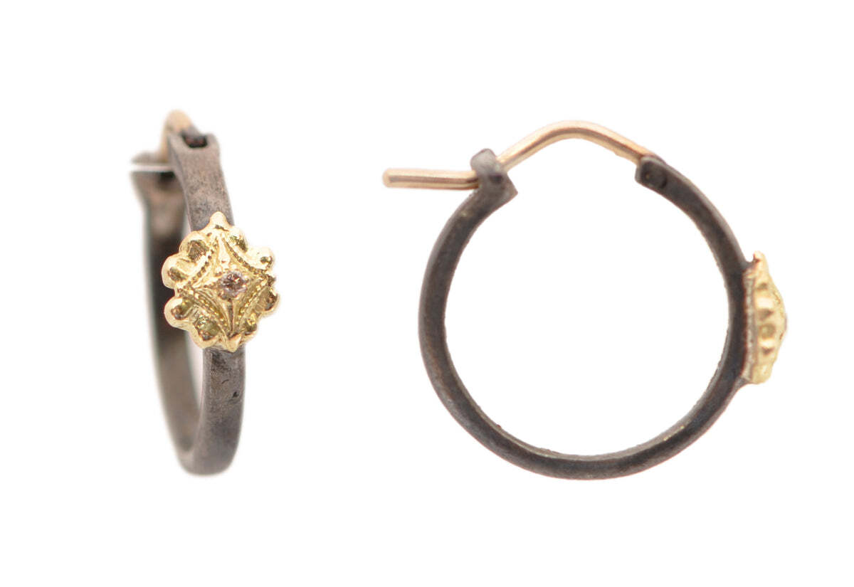These stunning 18k yellow gold and blackened rhodium finish sterling silver huggie earrings are the perfect accessory to any outfit. Classic and elegant, they will bring a unique touch of sophistication. The 13mm floral shape and 0.13TCW champagne diamonds make these earrings truly shine, measuring 14.7mmx2.5mm in size. Add these beautiful huggie earrings to your collection now and make a lasting impression. 13MM BLACKENED FLORAL HUGGIE HOOP EARRINGS