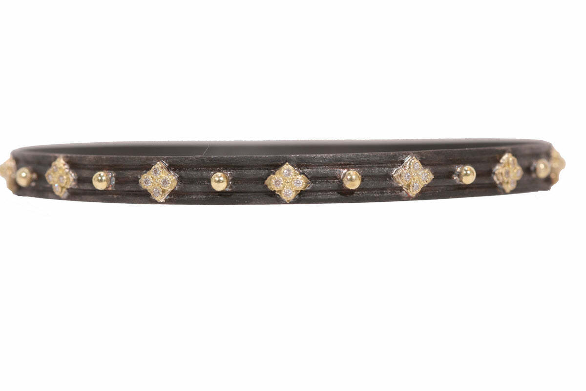 This exquisite 18K yellow gold and blackened sterling silver Crivelli and Granulation bangle bracelet with white diamonds (0.28 TCW) is the perfect addition to any jewelry wardrobe. The bold combination of yellow gold and black sterling silver makes a stunning statement. The bracelet is set with sparkling white diamonds (0.28 TCW) that add a luxurious touch. This bracelet is sure to become a favorite wardrobe staple and will provide years of enjoyment. Crivelli Bangle Bracelet