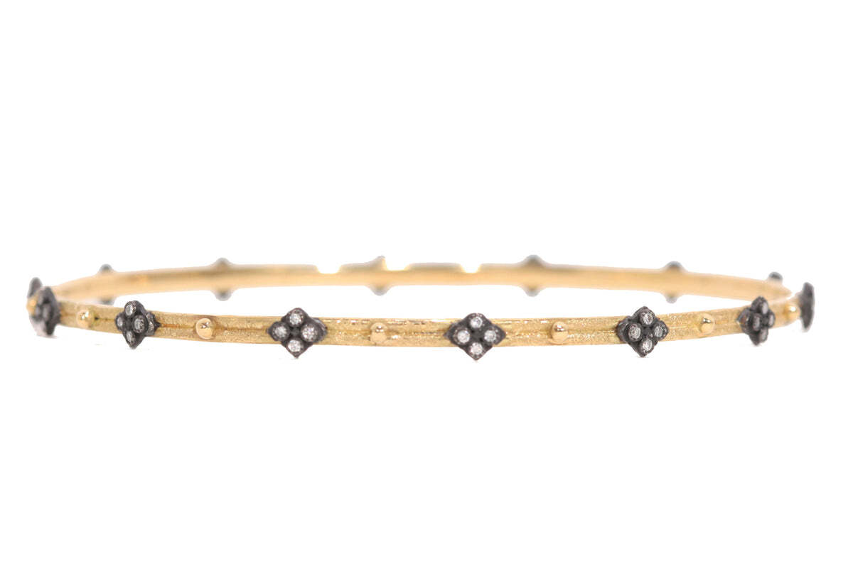 This stunning 18K Yellow Gold and Blackened Sterling Silver Crivelli and Granulation Bangle is the perfect addition to any outfit. Adorned with 0.28 carat total weight of white round brilliant-cut diamonds, this bangle sparkles with a classic elegance. The intricate granulation detailing on the center of the bangle and the intricate Crivelli engraving on the sides add a unique modern flare to the piece. This bangle will be the perfect accessory for any occasion, adding a touch of luxury and glamour to your look. Crivelli and Granulation Bangle Bracelet