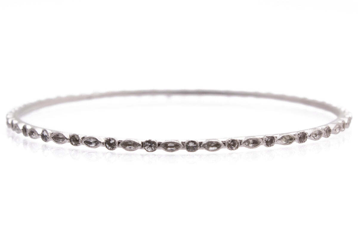 This exquisite sterling silver bangle bracelet is the perfect way to add classic style and sophistication to your ensemble. The splendid design showcases a marquis cut and round white sapphires, lending an eye-catching touch of sparkle. Crafted with quality materials and expert craftsmanship, this piece will become a timeless addition to your jewelry collection. Its delicate size and classic style make it a perfect accessory for any occasion, whether you dress up or dress down. Show off your individual style with this timeless piece of jewelry. Sapphire Bangle Bracelet