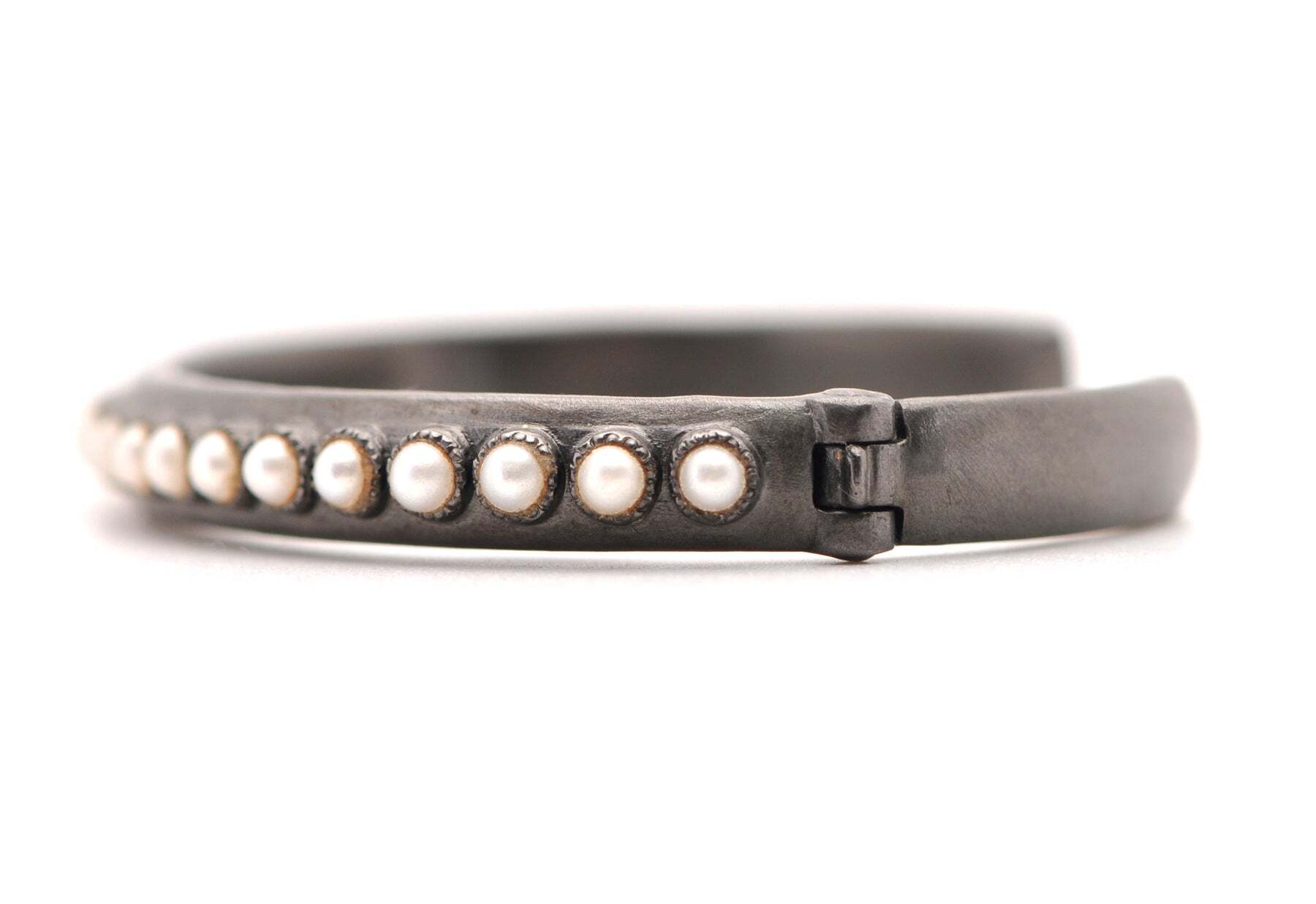 This stunning blackened sterling silver kick cuff bracelet showcases a freshwater cultured pearl creating an elegant style. Its sleek blackened silver finish adds a unique, edgy look to this classic style. The timeless combination of the pearls and the cuff bracelet combine for a modern and unique piece that will turn heads. The perfect addition to any wardrobe, this bracelet is sure to become your go-to accessory. Whether you dress it up or dress it down, this Blackened Sterling Silver Kick Cuff Bracelet with White Freshwater, Cultured Pearls will bring timeless style to any look. Pearl Cuff Bracelet