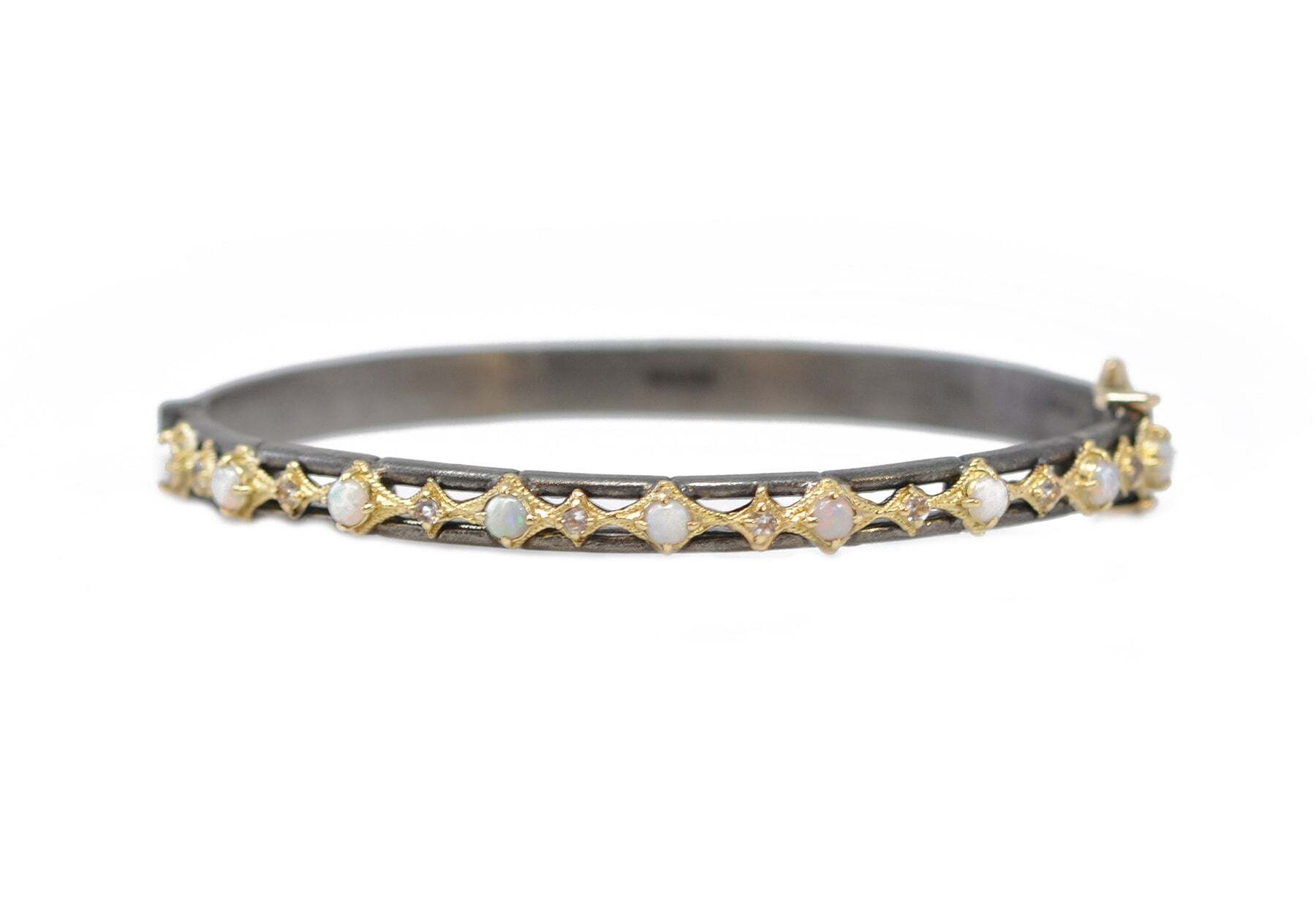 Slip your wrist into something special: this luxurious huggie bracelet, crafted in 18k yellow gold and dark sterling silver. Featuring a gorgeous peach morganite and dazzling white opals, this bracelet is a luxurious addition to your jewelry collection. The bracelet's huggie design gives you a secure fit and a stylish statement. With its dazzling gems and luxurious design, this is the perfect bracelet for special occasions or everyday wear. PEARLS AND "X" HUGGIE BRACELET