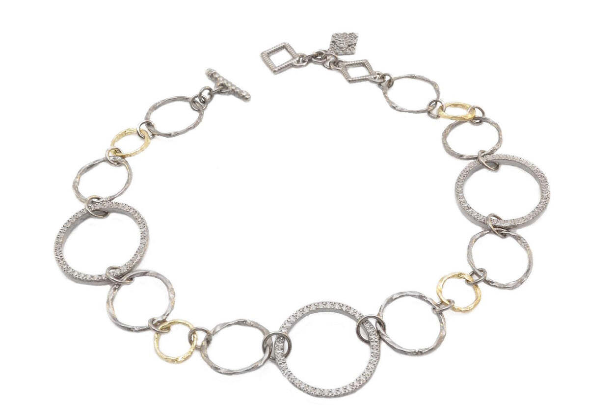 This 18K Yellow Gold and Grey Sterling Silver Necklace with Alternating Textured Circle Links is the perfect jewelry piece for everyday wear. Crafted with an alternating pattern of textured circle links, this necklace is both stylish and eye-catching. The necklace is adjustable to 18" and 20", and is made from 18K Yellow Gold and Grey Sterling Silver. This necklace is sure to make a statement, no matter where you go. Carved Link Chain Necklace