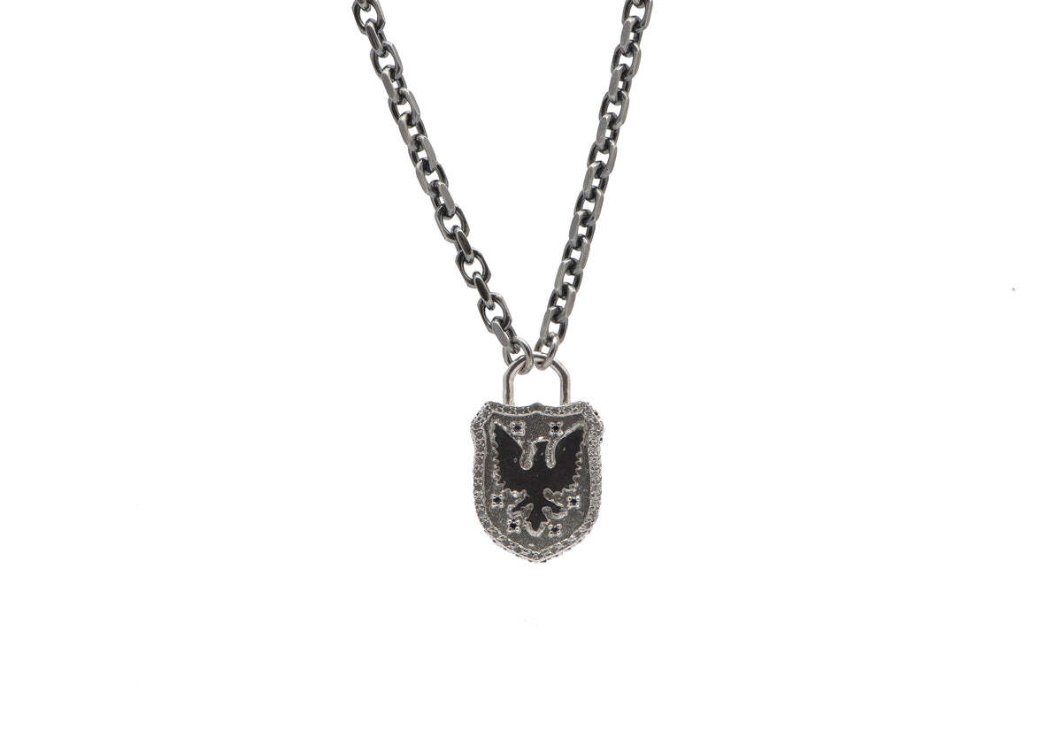 This sterling silver and blackened sterling silver 24" necklace is the perfect statement piece to add to any style. Featuring a sleek griffin shield pendant and adorned with five black sapphires, this necklace is sure to turn heads! It is adjustable at 22" and 24" to fit you perfectly. Whether you are a fan of talisman styles or just want to stand out, this is the perfect necklace for you. Its unique design, beautiful craftsmanship and understated sparkle of black sapphires makes this piece a must-have. Griffin Shield Necklace