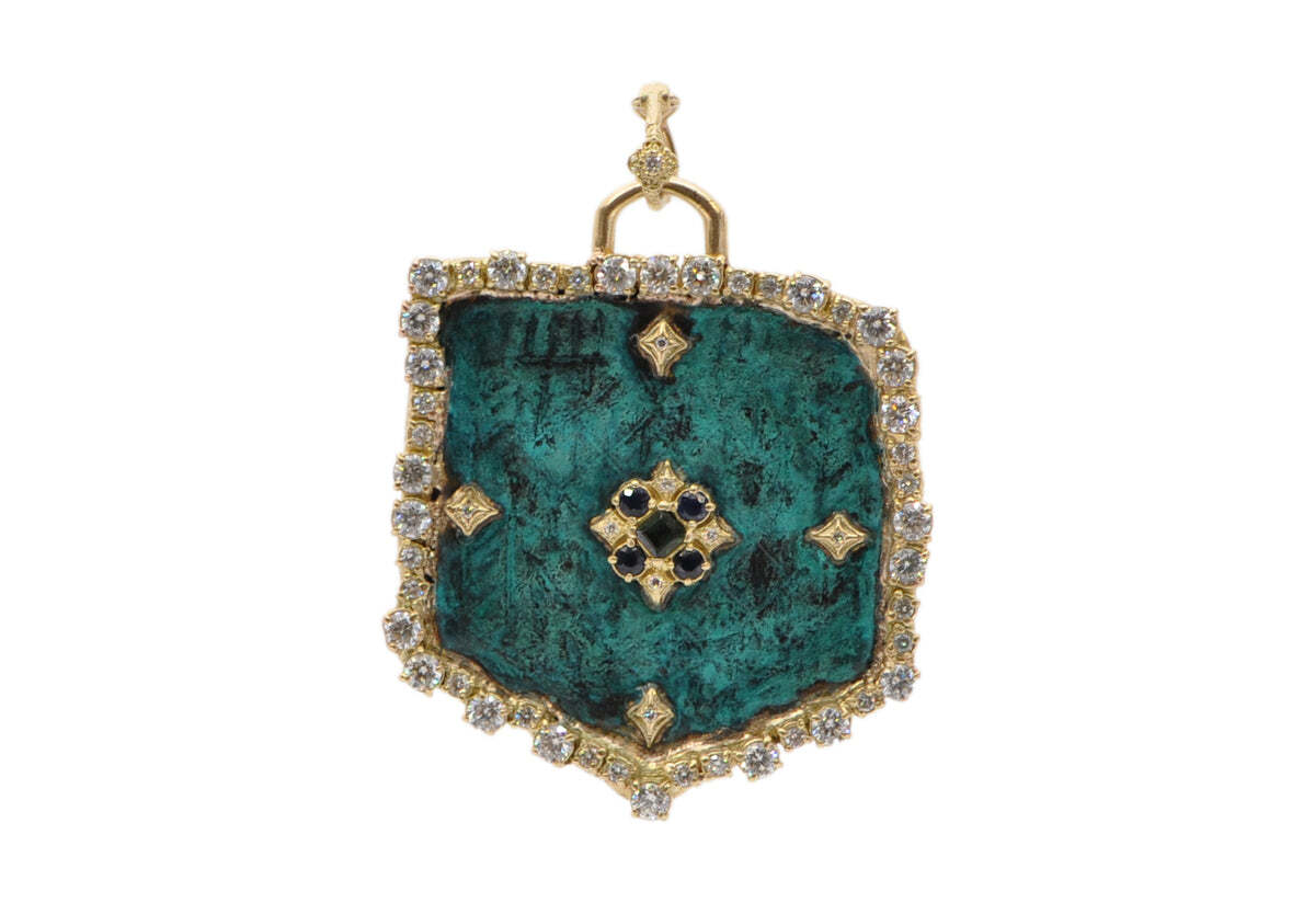 This stunning artifact shield is crafted from a luxurious 18k yellow gold and delicately inlaid with a beautiful masterwork from the renowned painter Carlo Crivelli. Further embellishments of deep blue sapphires and 2.7 carats of magnificent round white brilliant diamonds with teal patina bring a sense of drama to this one-of-a-kind piece. Measuring an impressive 50.74mm by 42.55mm, this shield is sure to make a statement with its unique beauty. Or, if you prefer, you can wear it with 56.84mm of grandeur with the bail to make an even more regal impression. 50MM ARTIFACT SHIELD ENHANCER