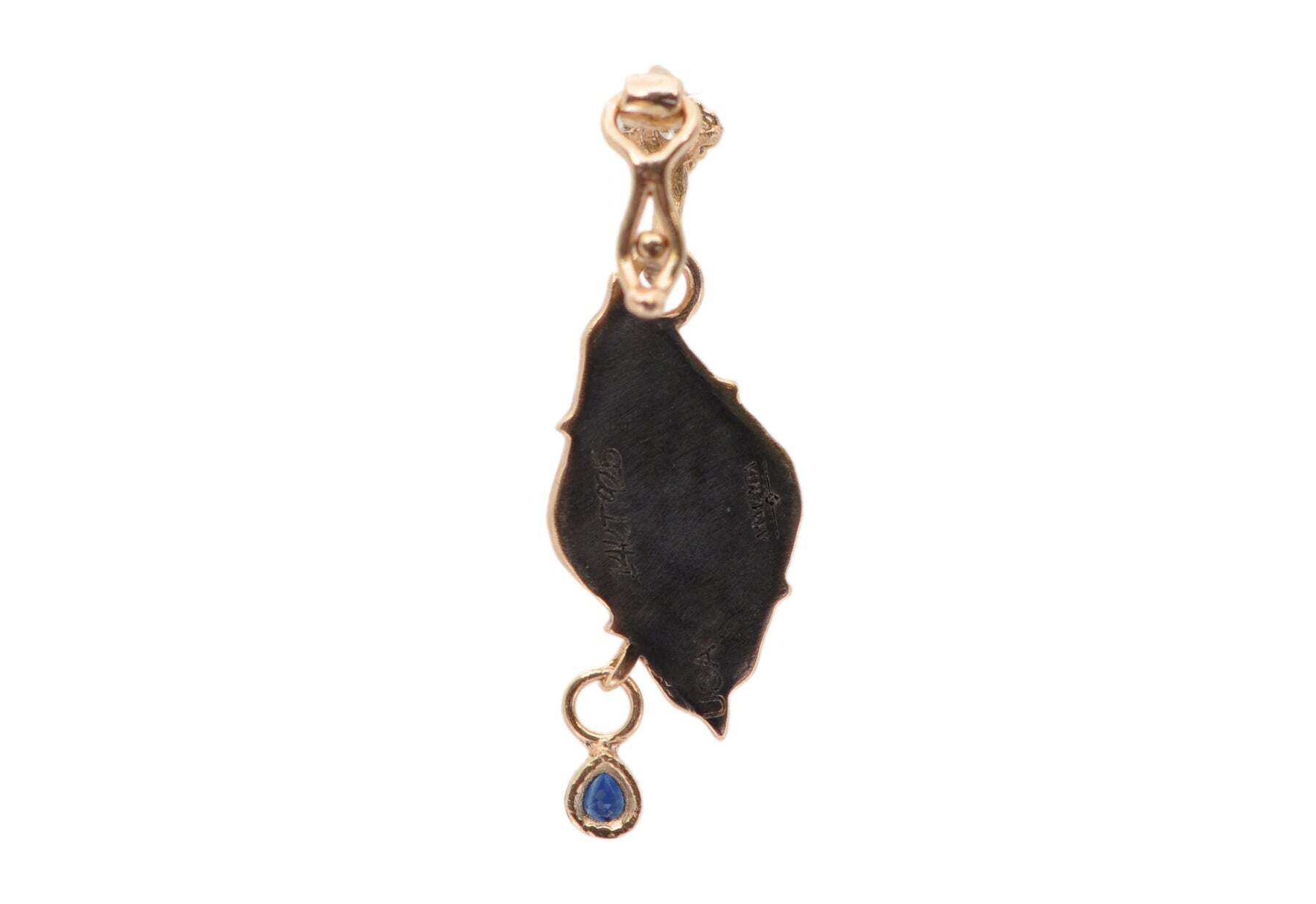 This gorgeous eye enhancer is perfect for adding a touch of understated elegance to your look. Crafted from 14k rose gold and rhodium finished sterling silver, this timeless piece boasts a captivating blue turquoise center, white enamel eye, blue sapphire teardrop, white diamond, and champagne diamonds, for a total of 0.10 carats. At 10.7mmx21mm, this eye enhancer is a perfect accessory for any special occasion. EVIL EYE WITH TEARDROP ENHANCER