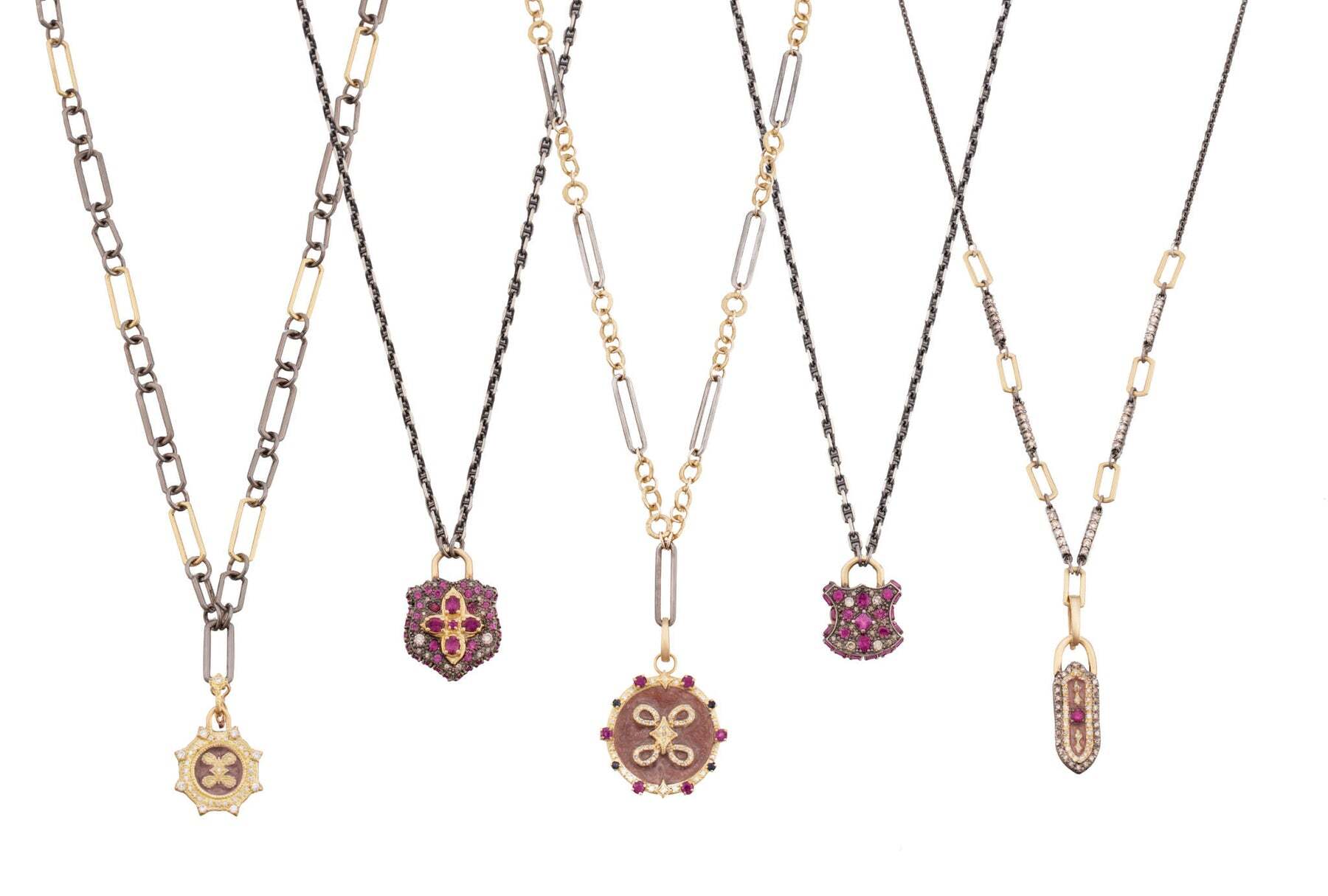 This stunning pendant is a beautiful combination of 18k yellow gold and blackened sterling silver and is adorned with a timeless combination of dusty rose enamel, regal purple garnets, and 0.28 CT white and champagne diamonds. The intricate details and exquisite craftsmanship of this piece will make it an eye-catching accessory and an exquisite addition to any jewelry collection. With its striking and unique design, this pendant is sure to turn heads and make a statement. Be the envy of all your friends and family with this stunning piece of jewelry! ELONGATED SHIELD DUSTY ROSE ENAMEL PENDANT