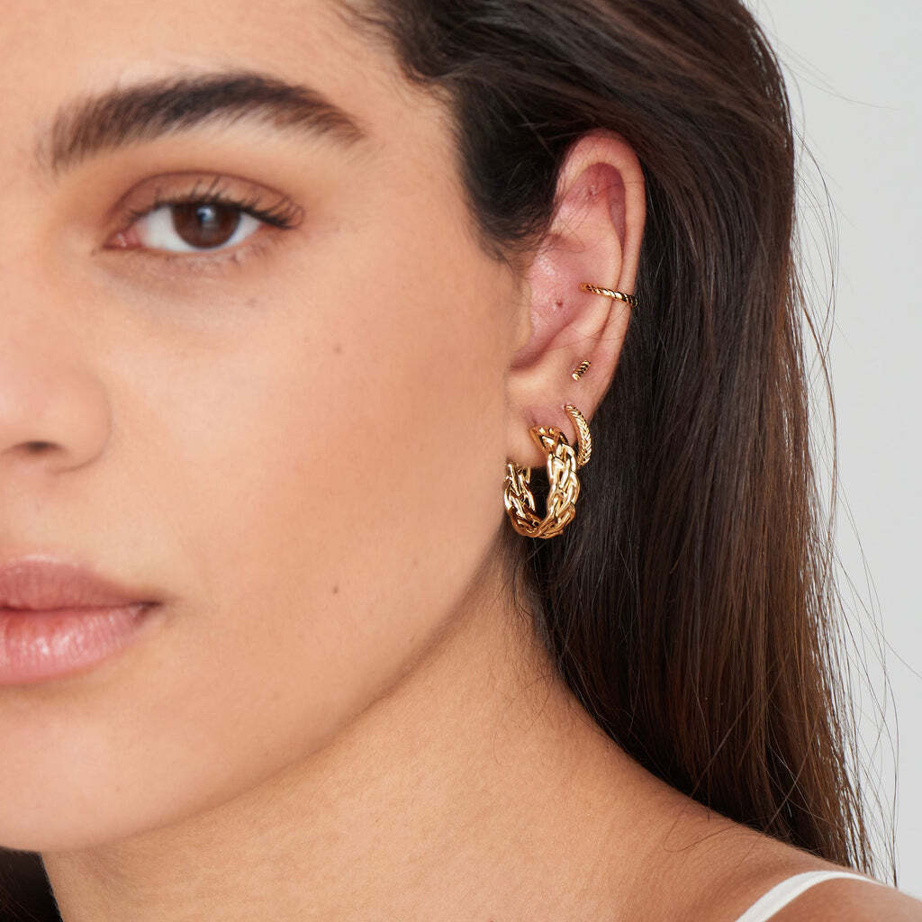 Crafted with an on-trend textured plait effect, these striking gold huggie hoop earrings make the perfect alternative to your everyday hoops. Inspired by rope and this season’s Maritime trend, it’s all about added texture and depth with these chunky everyday huggie hoops. Simply add a stack of studs or additional huggies to create a unique look. • Hoop size: 12mm • Weight: 1.4g Gold Rope Huggie Hoop Earrings
