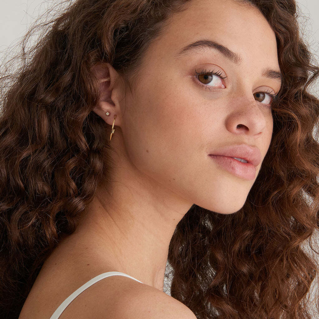 Don’t choose between sleek style and colour. Our enamel hoops nail both aesthetics to perfection. The perfect size to take centre stage, add them to a stack or keep your look clean and simple. These modern single-sided gold hoops are finished with an optic white enamel coating for a versatile touch of fun for any look. OPTIC WHITE ENAMEL GOLD HOOP EARRINGS