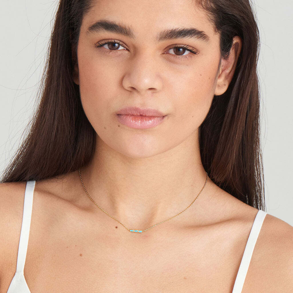 When one turquoise-color stone won’t do, why not opt for three? This stunning and simple chain is complete with three turquoise-color stones, lined up for a modern twist on turquoise jewelry. The perfect gold necklace with turquoise to add color to a layered necklace look, style yours with delicate chains or add a choker for extra on-trend ‘90s vibes GOLD TURQUOISE BAR NECKLACE