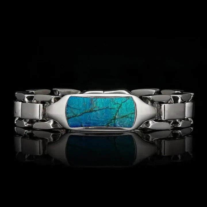 Bring the colors of the sky at dusk to life with the 'Labradorite Identity'. Sculpted sterling silver, hand polished in blended mirror and brush finished surfaces, houses a centerpiece of inlaid labradorite. Undulating tones of blue, green, purple, and black play against the natural grain of the material, revealing nature’s majesty. Finished with our button lock inset with a spinel gemstone, and including engraving space on the back of the center ID tag. LABRADORITE IDENTITY