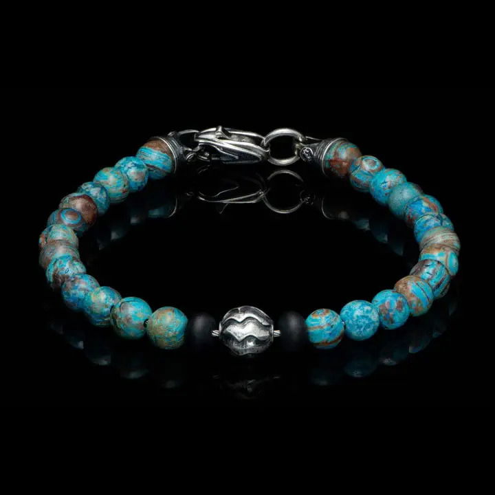 This bracelet started with a custom designed silver bead, made in our studio, that features a pattern inspired by the sculpted sand dunes at the Oregon coast. That quiet but powerful centerpiece, flanked by matte onyx rondelles, is supported by a beautiful strand of Blue Lace Agate beads, and finished with sterling caps and a custom lobster clasp. Simple, elegant, timeless, and easy on its own or stacked. BROOKINGS - BLUE AGATE