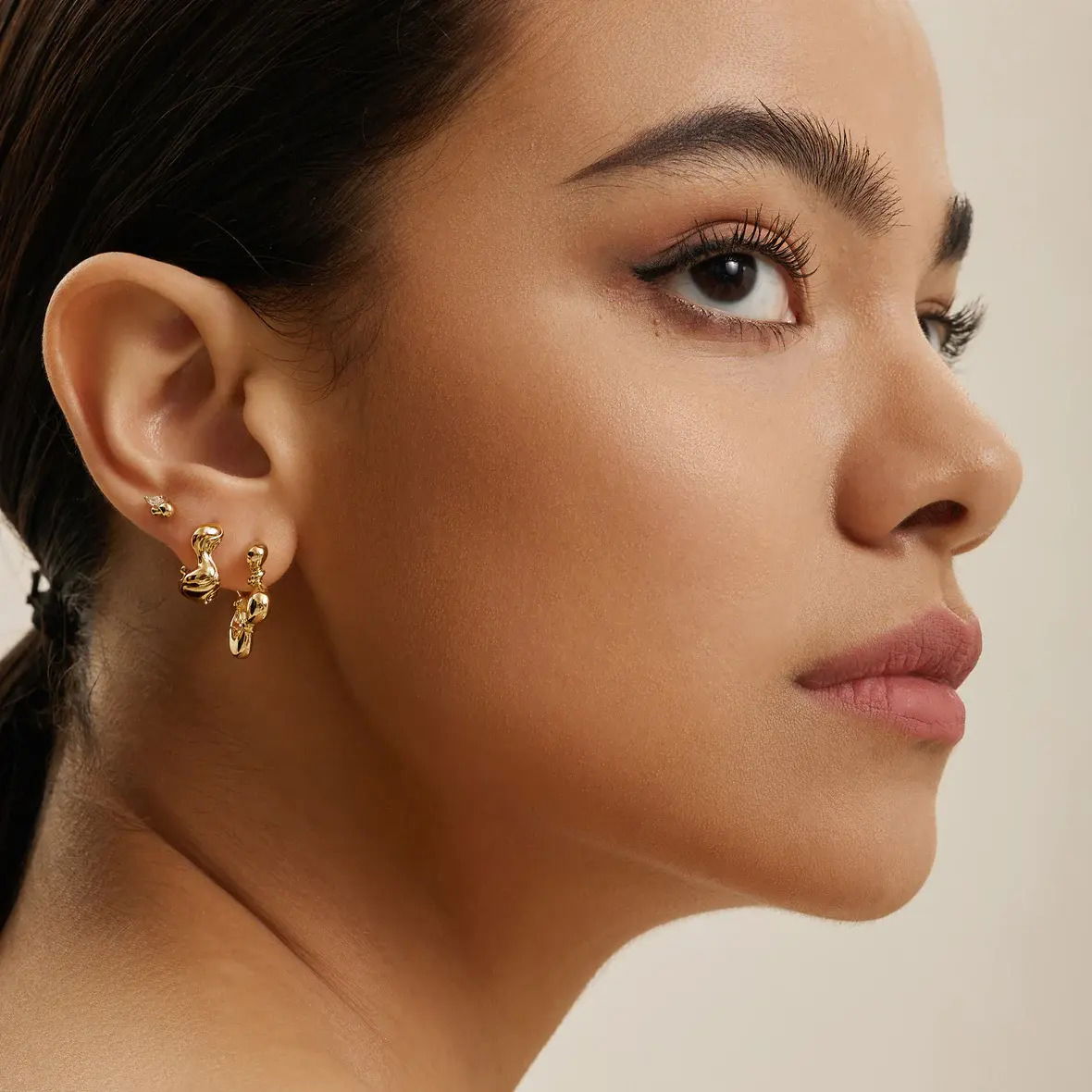 Product Description:An on-trend take on a classic stud earring, these unique studs pair chunky twisted metal with pear-shaped cubic zirconia stones for a sparkling addition to your everyday jewellery collection. Crafted in sterling silver and plated in 14kt gold, these chic stud earrings are the ultimate way to elevate a minimal look. Easy to wear solo or stacked for extra oomph. Product Details:• Material: 14kt gold plated on sterling silver with Cubic Zirconia• Earring size: 4.4mm x 6.8mm• Weight: 1.6g Gold Twisted Wave Stud Earrings
