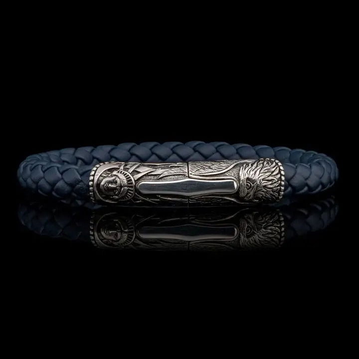 The Blue Ridge brings our honored American heritage to life, timeless images sculpted from generations past, and for generations into the future. This bracelet features a beautifully carved centerpiece/clasp in sterling silver with a double secured magnetic closure. The antique white of the sterling is the perfect pairing to a supple and durable 8mm braided leather cord in an earth-tone blue/gray that wears well with any outfit, on any occasion. BLUE RIDGE