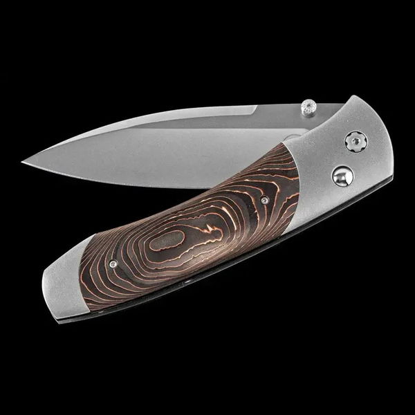 Closeup photo of Titanium pocketknife with compressed Copper Swirl Carbon Fiber and stainless blade