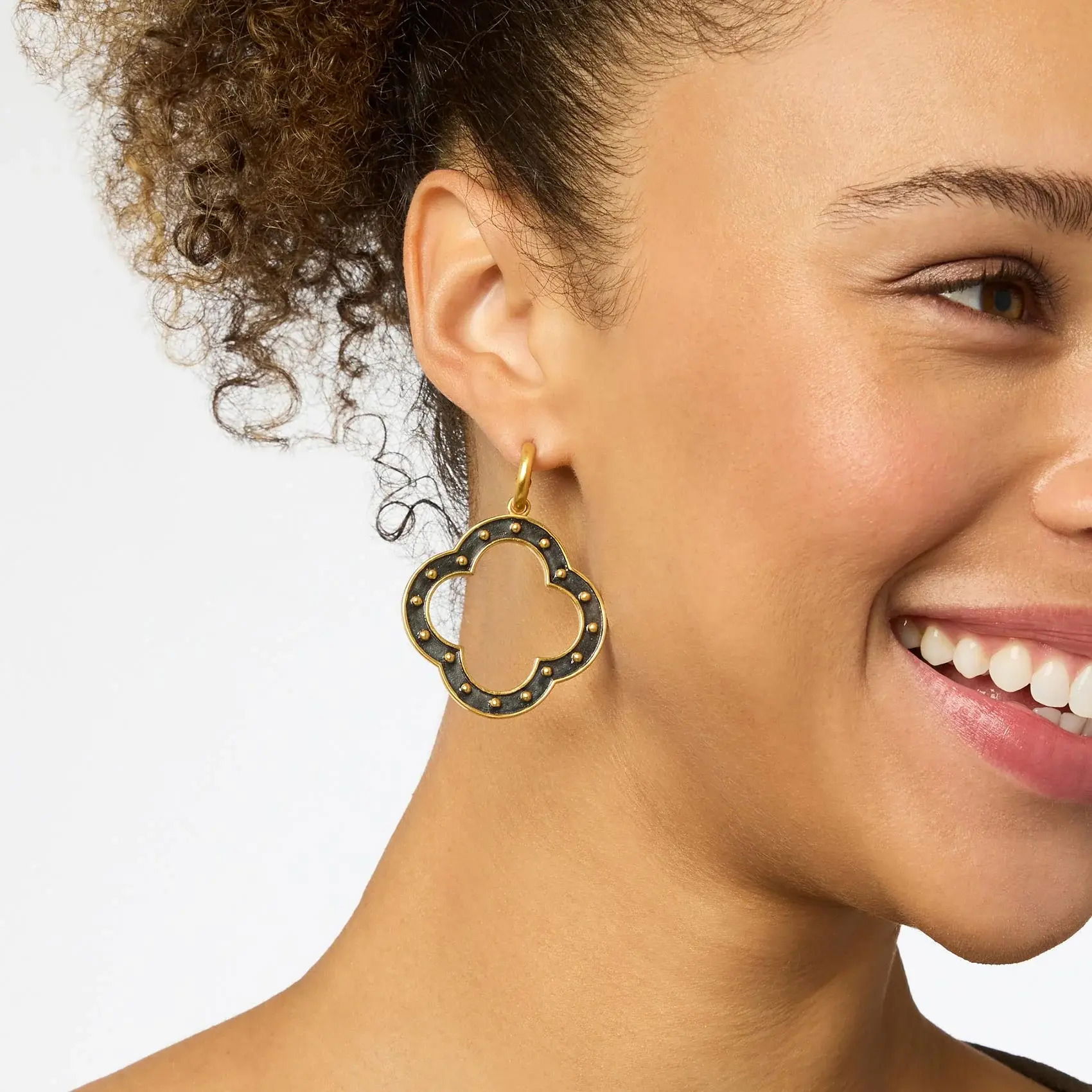 Gold quatrefoil charms with a studded motif that recalls SoHo’s timeless cast-iron architecture swing from softly polished huggie hoops. SoHo Statement Hoop & Charm Earring