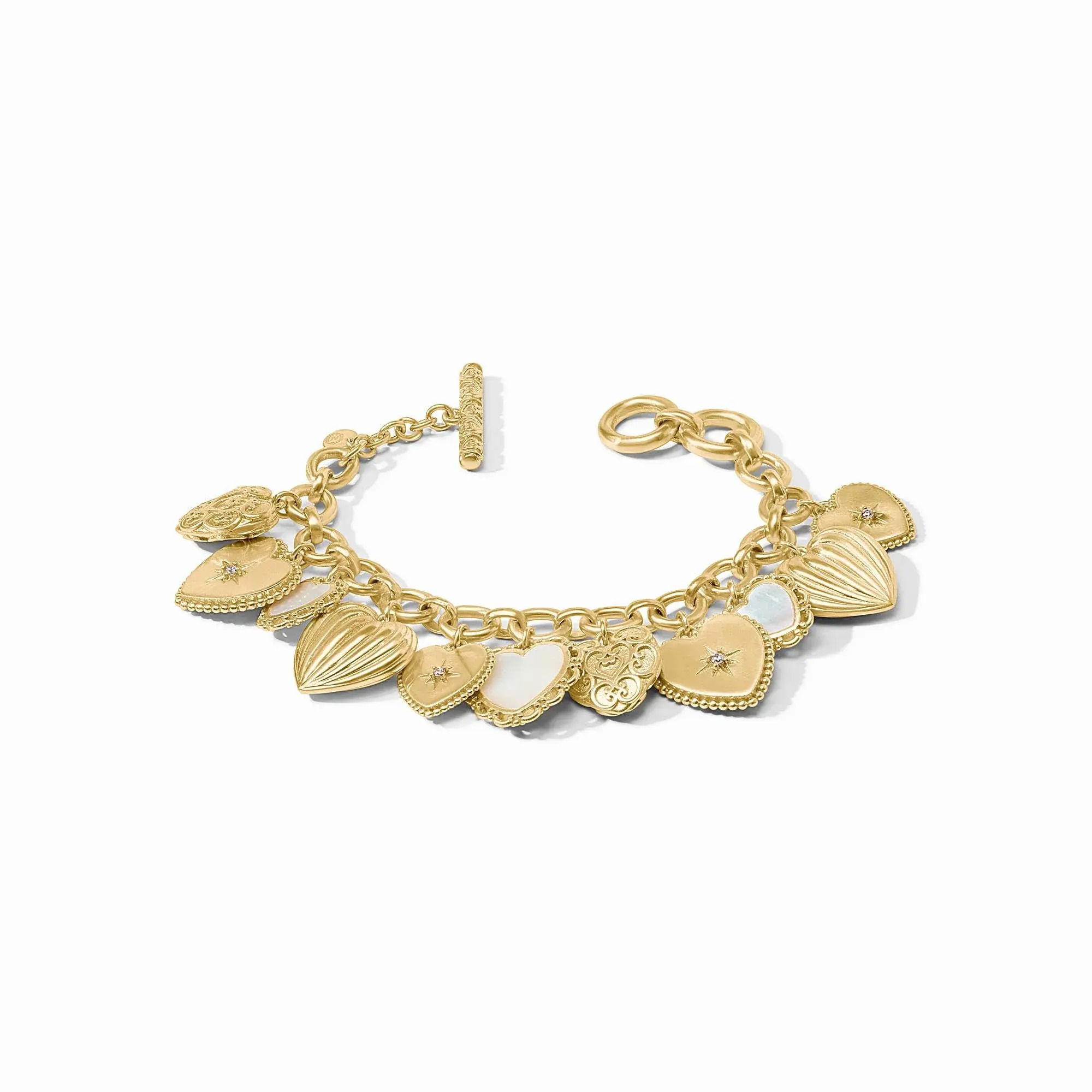 A bracelet of ornate, vintage-inspired gold heart charms, featuring sparkling gemstones, shimmering mother of pearl, and delicate latticework dangling from an airy cable chain that closes with an ornate adjustable toggle. Heart Charm Bracelet