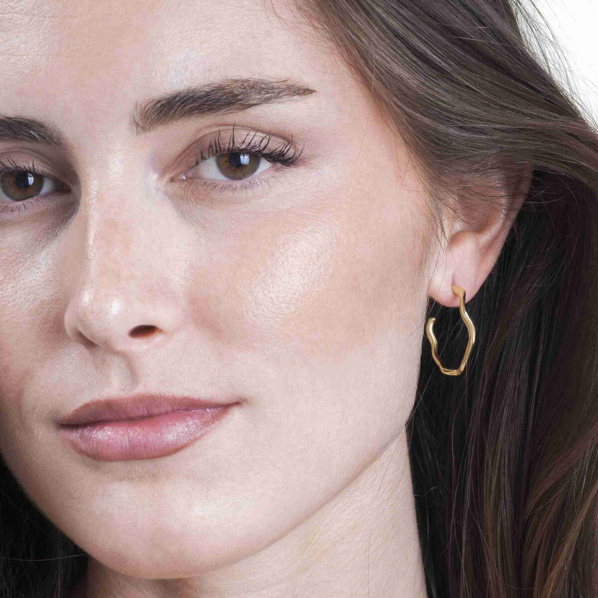 Irregular hoop earrings from the Rolling by Jorge Revilla collection, crafted in 925 sterling silver with 18k gold vermeil and designed with asymmetrical and organic shapes that bring a contemporary and elegant touch.Measuring 28 mm in length, they are lightweight and comfortable for all-day wear, perfect for casual occasions or special events.Their unique design reflects the essence of Rolling, inspired by movement, freedom, and the beauty of nature. Ideal for those seeking an accessory with character and personal style.Metal: 925 sterling silver with 18k gold vermeilLength: 28 mmCollection: Rolling by Jorge Revilla Irregular hoop earrings in sterling silver with 18k gold vermeil