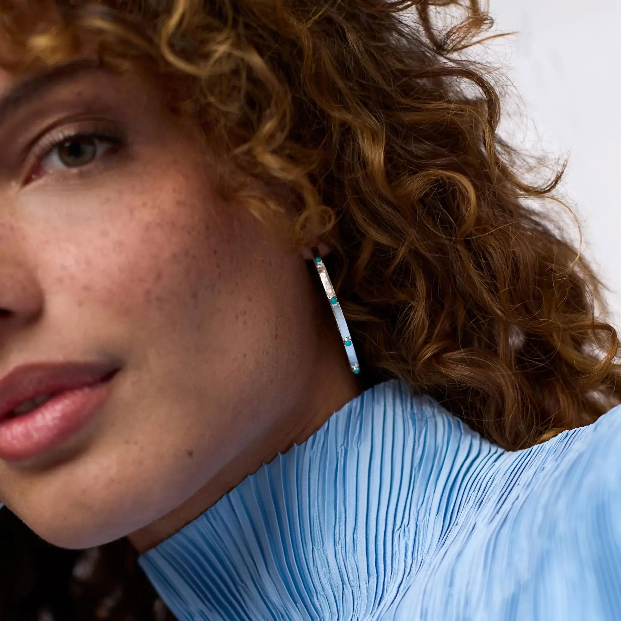 Pure silver plate (tarnish-free), reconstituted stoneLength: 1.3 inches (medium), 1.8 inches (large), 2.1 inches (extra large)Post for pierced earsIncludes pure silver plated earring backs CRESCENT STONE HOOP SILVER - TURQUOISE BLUE