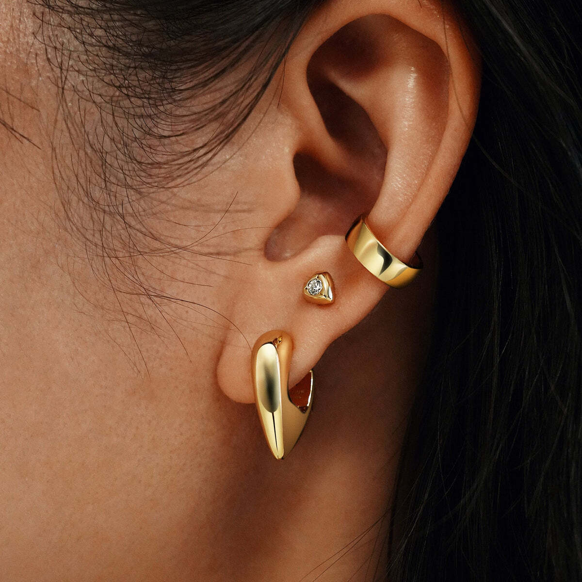Product Description: Ready to take on the world this season? Embrace your inner strength and confidence with these shield huggies. Designed for the fearless woman who commands attention. Mix and match with other studs, huggies and hoops to making a statement. Product Details: ? Material: 925 Sterling Silver with 14kt G Gold Puffy Shield Huggie Hoop Earrings– Ania Haie US