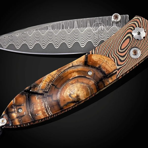 Closeup photo of Smoky - Pocketknife featuring mokume gane, fossil Mammoth tusk and 'wave' damascus blade
