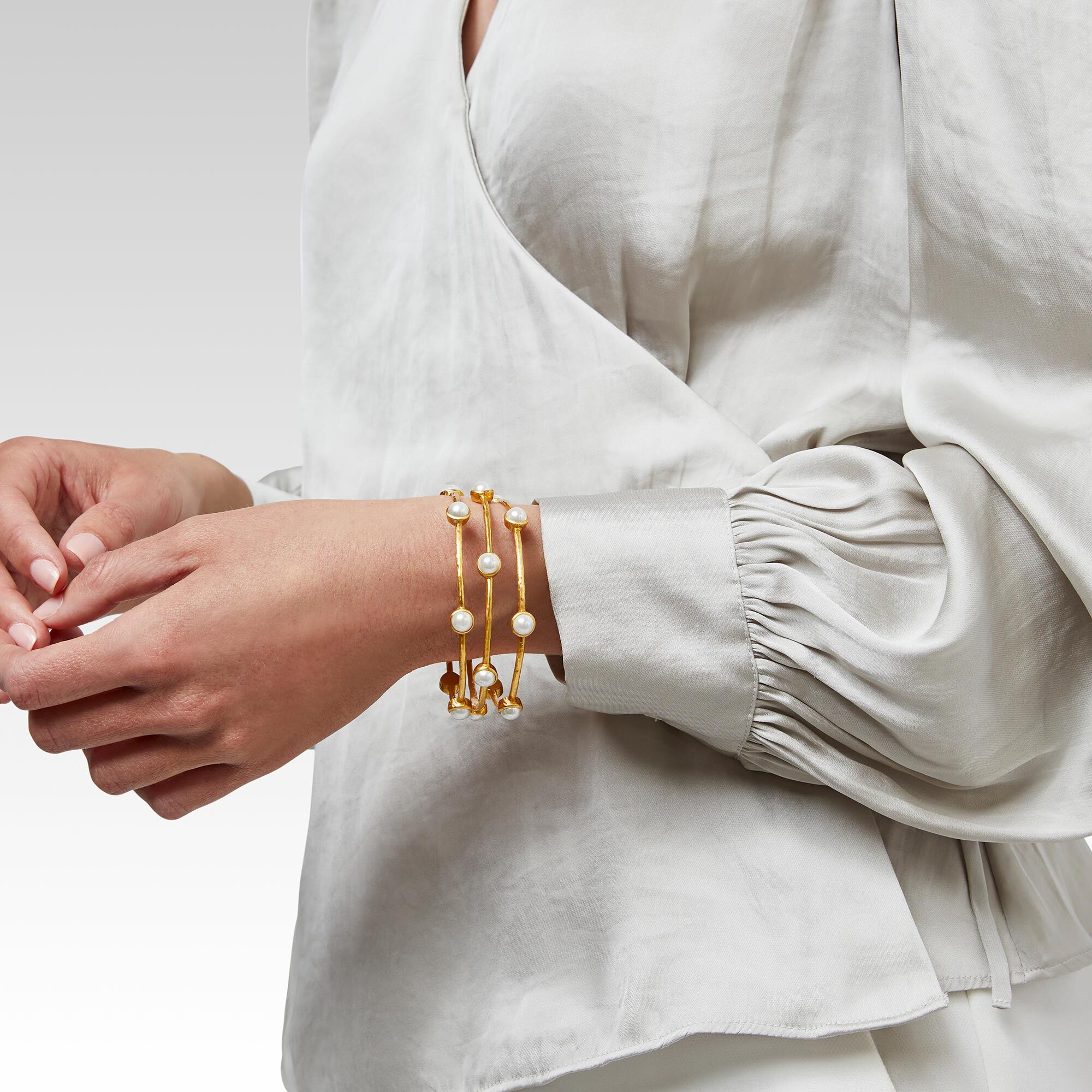 A lightly hammered bangle embellished with six pearl stations. Milano Luxe Pearl Bangle