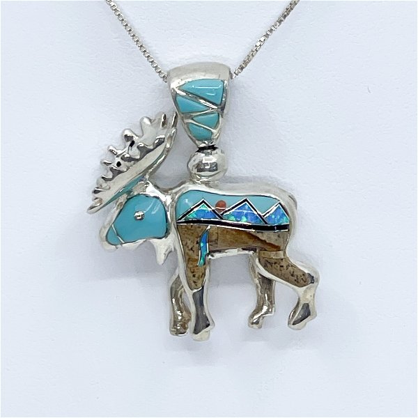 Closeup photo of Sterling Silver Gl Reversible Moose Pendent with mountain scenery